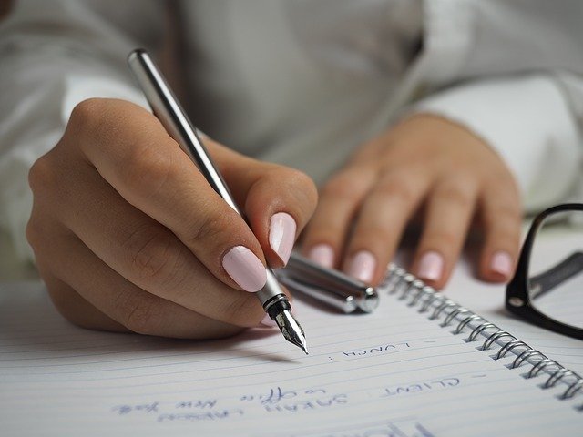 mulher escrevendo com caneta
