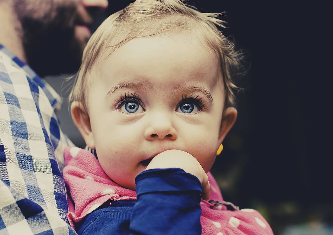 bebê de olho azul encarando